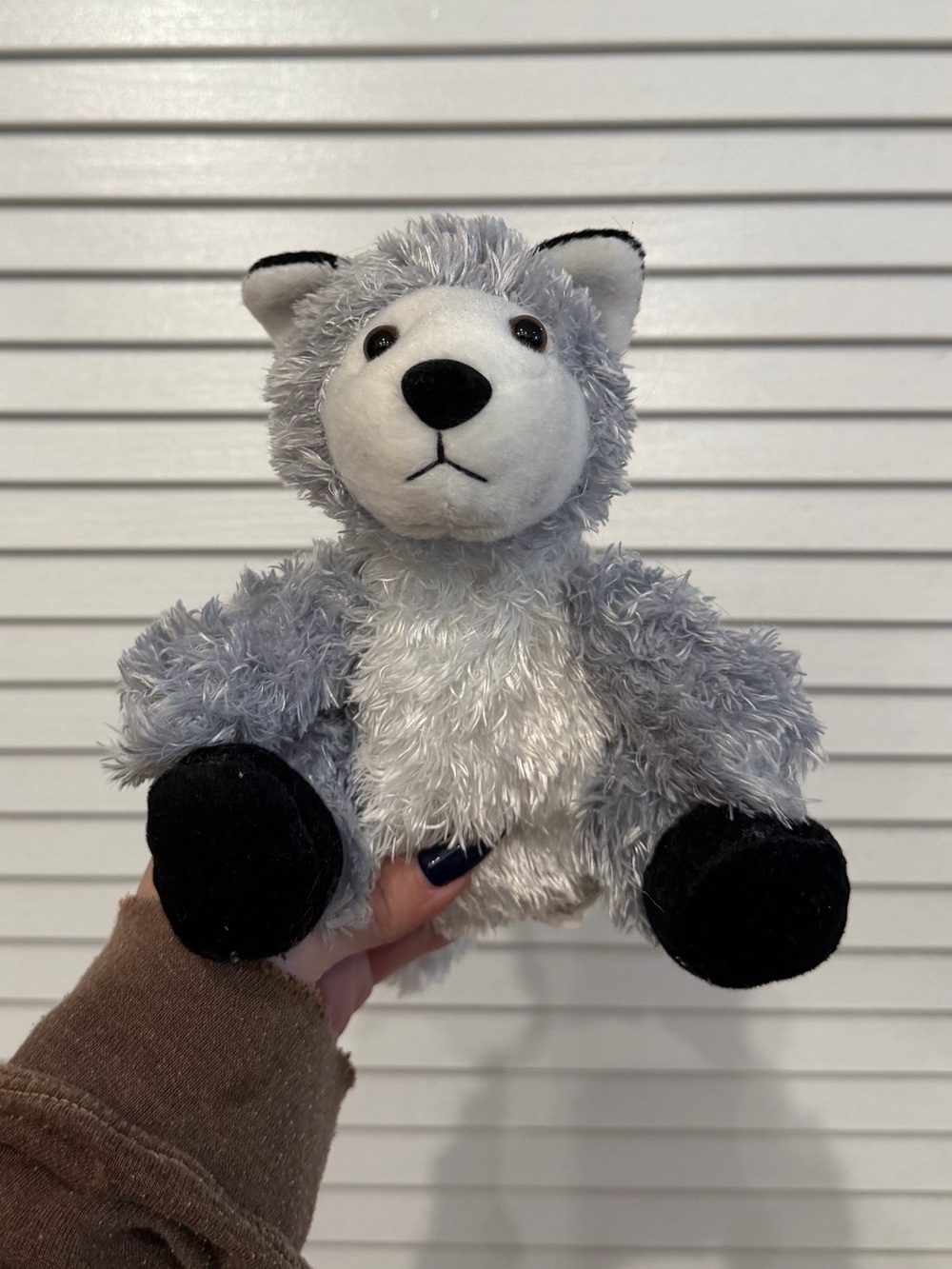 Gray wolf plushie stuffed animal with black paws and ears